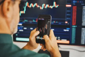 Inwestor analizuje wskaźniki TradingView na wykresach w telefonie i na komputerze